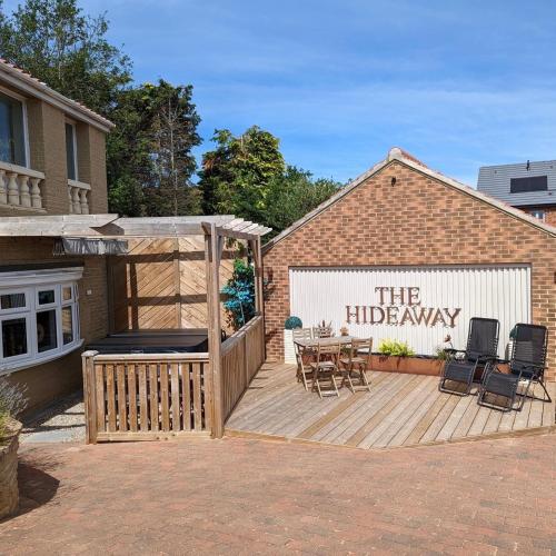 a building with a patio with a table and chairs at The Hideaway Thorpe Thewles in Thorpe Thewles