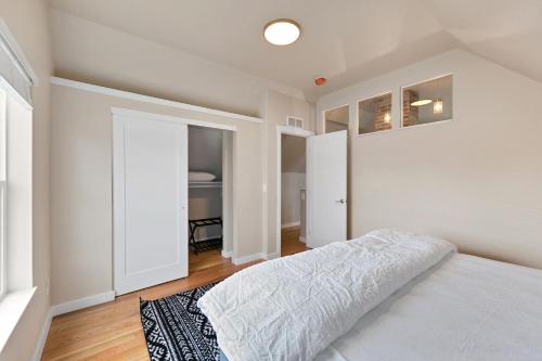 a white bedroom with a bed and a closet at Bright and Stylish Home - Great Central Location! in Timnath