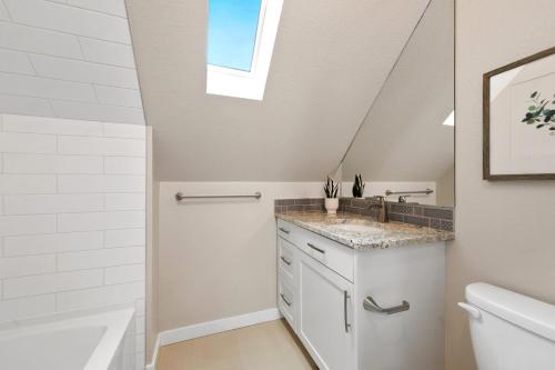 a bathroom with a sink and a skylight at Bright and Stylish Home - Great Central Location! in Timnath