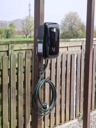 a television attached to a fence with a hose at Villa Vili - Jacuzzi, BBQ & EV Outlet in Limbuš
