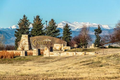 a building with a sign in a field with mountains in the background at Charming Home with RV Parking - 30 miles from RMNP! in Loveland