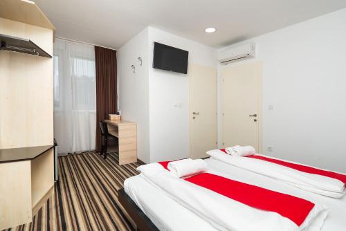 Duas camas num quarto com uma televisão de ecrã plano em ParkCity rooms em Sibenik