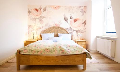 1 dormitorio con 1 cama y papel pintado con motivos florales en Villa Wilhelma Strandallee 146 Villa Wilhelma Apartment 18, en Timmendorfer Strand