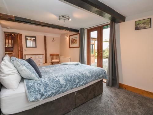 a bedroom with a bed with blue and white sheets at Lake View Cottage in Longford