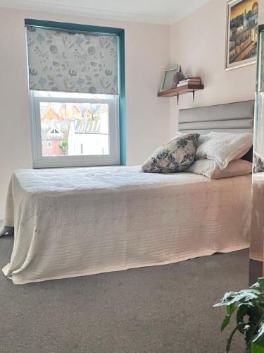 1 dormitorio con 1 cama grande y ventana en Cozymodrenroom, en Brighton & Hove