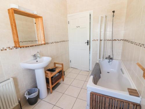 a bathroom with a sink and a bath tub and a sink at 2 Ocean View in Doonbeg