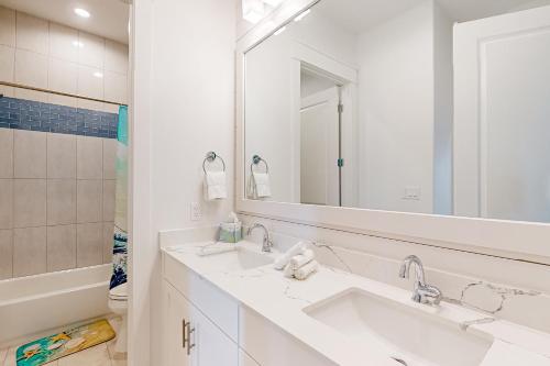 un bagno bianco con due lavandini e uno specchio di Coastal Vista Retreat a Port Aransas