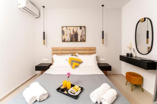 a bedroom with a bed with a tray of food on it at Anassa Villas in Keratokampos