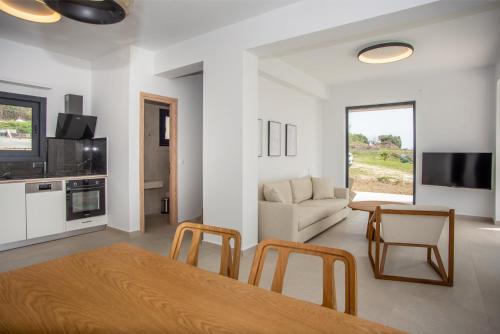 sala de estar con mesa, sillas y sofá en Sea Whisper with Private Pool & Panoramic Sea view, en Plateies