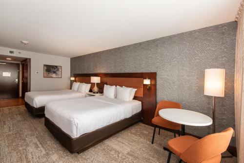 um quarto de hotel com duas camas e uma mesa e cadeiras em Quality Inn & Suites em Val-dʼOr