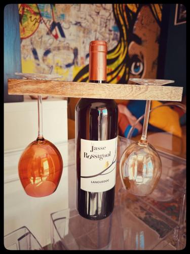 - une bouteille de vin sur une étagère avec deux verres à vin dans l'établissement Centre port,vue panoramique,Clim,Balcon,wifi, au Cap d'Agde