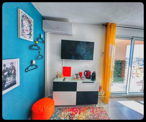 a room with a desk with a blue wall at Centre port,vue panoramique,Clim,Balcon,wifi in Cap d'Agde