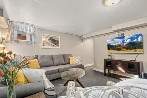 a living room with a couch and a tv at Garden Level Apt Mtn Ave - 8 min walk to Old Town! in Fort Collins