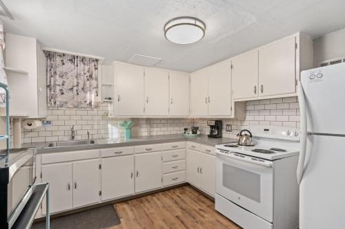 una cocina con armarios blancos y electrodomésticos blancos en Garden Level Apt Mtn Ave - 8 min walk to Old Town!, en Fort Collins