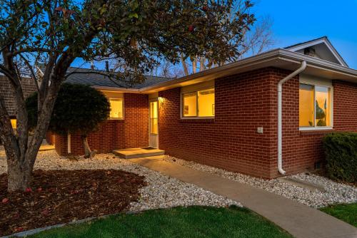 une maison en briques avec un arbre devant elle dans l'établissement Couples Getaway - Dog Friendly, Bike to Old Town!, à Fort Collins