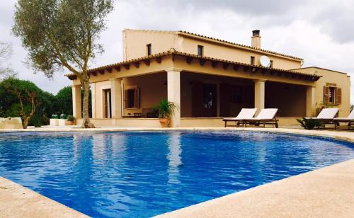 uma villa com piscina em frente a uma casa em SON BUSQUERET em Ses Covetes