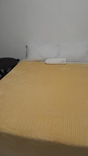 een bed met een gele deken erop bij 17 driffield road in East London