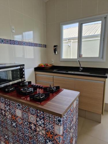 a kitchen with a stove and a counter top at Casa em condominio in Catalão