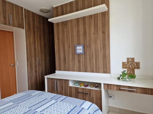 a bedroom with a bed and a wooden wall at Casa em condominio in Catalão