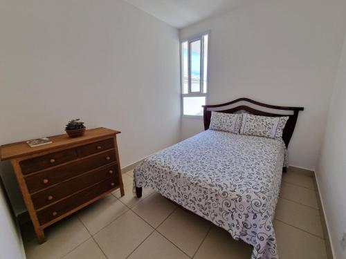 a bedroom with a bed and a dresser and a window at Casa em condominio in Catalão