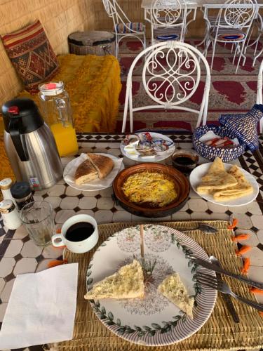 a table with plates of food on top of it at Aladdin Desert Camp - Mhamid Erg Chigaga Escape in El Gouera