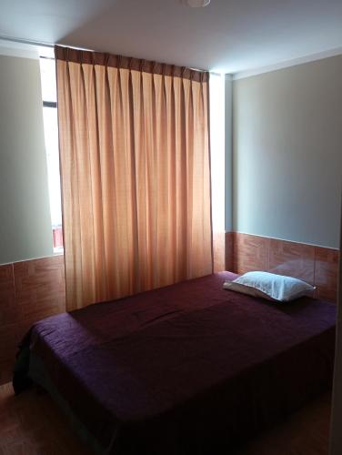 1 dormitorio con 1 cama grande y ventana en Goya'sHostel, en Camaná