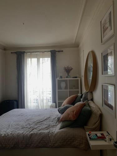 une chambre avec un lit avec un miroir et une fenêtre dans l'établissement Appart sympa, à Paris
