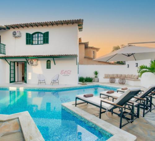 une villa avec une piscine et une maison dans l'établissement Elsi Pousada, à Búzios