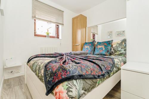 um quarto com uma cama com um edredão colorido em The Merchants Gem - 2Bed & Free Parking em Glasgow