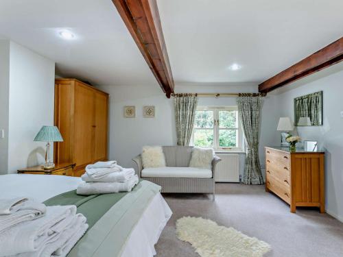 ein Schlafzimmer mit einem Bett, einem Stuhl und einem Fenster in der Unterkunft 4 bed in Okehampton 49511 in Sampford Courtenay