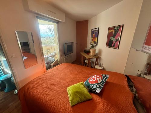 a bedroom with a bed with an orange comforter at Splendide appartement 40m2 familial cabourg in Cabourg