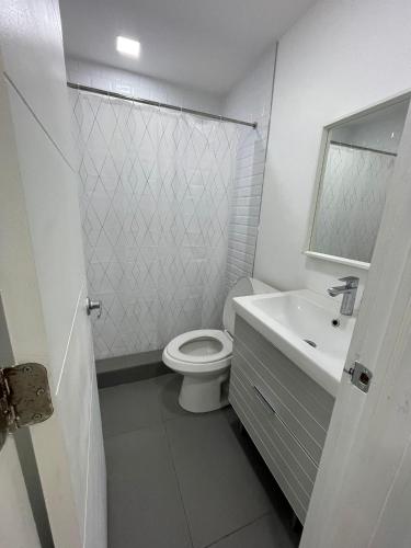 a white bathroom with a toilet and a sink at Stylish Pool Home in Hollywood