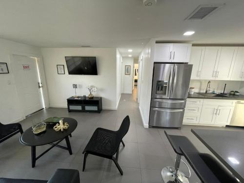 a kitchen and living room with a refrigerator and a table at Stylish Pool Home in Hollywood