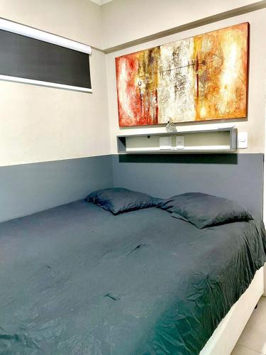 a bedroom with a bed and a painting on the wall at Studio 219 em Santos in Santos