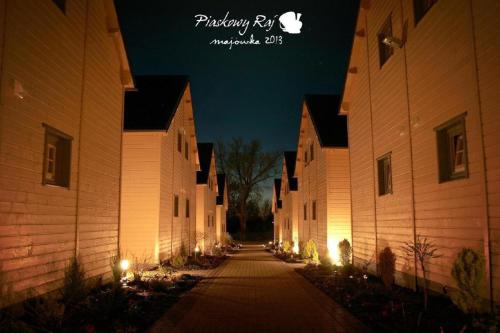 una fila di edifici di notte con luci accese di Wohnung in Paprotno mit Grill und Garten a Gąski