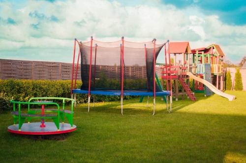 un parco con parco giochi con scivolo di Wohnung in Paprotno mit Grill und Garten a Gąski