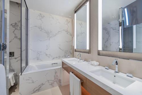 a bathroom with a sink and a tub and a mirror at Address Opera Residences - Elegant Dubai in Dubai