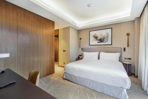 a hotel room with a bed and a table and a desk at Luxury 1BR The Address Opera, Downtown Dubai in Dubai