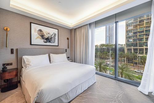 a bedroom with a large bed and a large window at Address Opera Residences - Elegant Dubai in Dubai