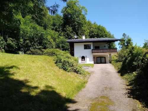 a house on a hill next to a dirt road at Gemütliches Landhaus in Panorama-Lage mit herrlichem See- und Bergblick in Vichtau
