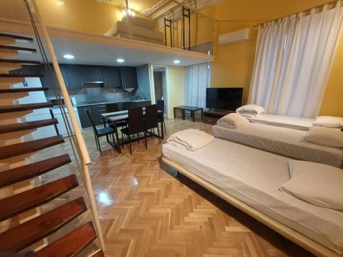 Habitación con 2 camas y cocina con mesa. en Apartamentos Sol Mayor, en Madrid