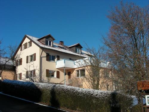 una casa bianca con una recinzione di fronte di Haus Holzheimer mit dem einzigartigen Blick auf Bad Kissingen und die Rhön - b43286 a Bad Kissingen