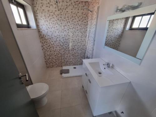 a white bathroom with a sink and a toilet at Alvorada Lunar in Almeirim
