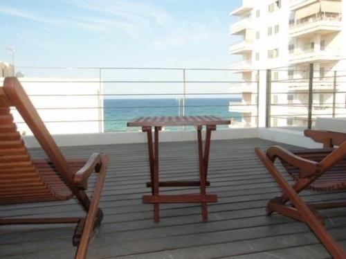 un tavolo e sedie su un balcone con vista sull'oceano di Appartement in Son Baulo mit Terrasse a Can Picafort