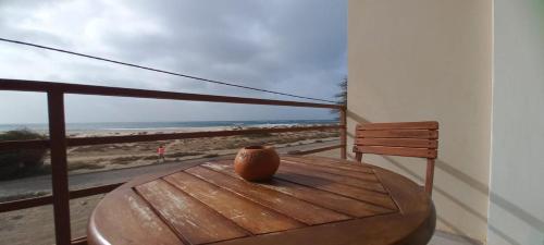 a vase sitting on a wooden table on a balcony with the beach at Sal Rei apartaments, Boa Vista, free WI-FI in Sal Rei