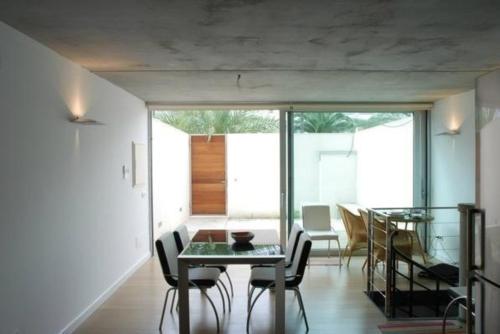una sala da pranzo con tavolo in vetro e sedie di Appartement in Son Baulo mit Terrasse a Can Picafort