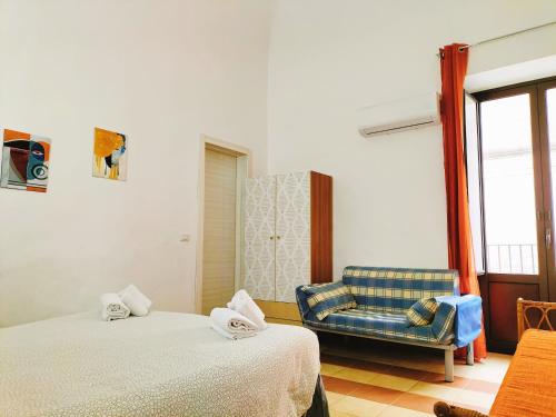 una camera con due letti e una sedia blu di Odeon Homes - Centro Storico a Catania