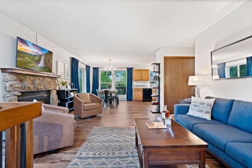 a living room with a blue couch and a table at The Horsetooth Stoop - Biking, Boating & Sunsets in Fort Collins