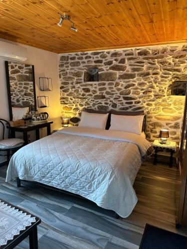 a bedroom with a bed and a stone wall at Old Town Traditional Residence in Kavala