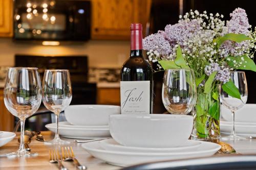a table with glasses and a bottle of wine and flowers at The Horsetooth Stoop - Biking, Boating & Sunsets in Fort Collins